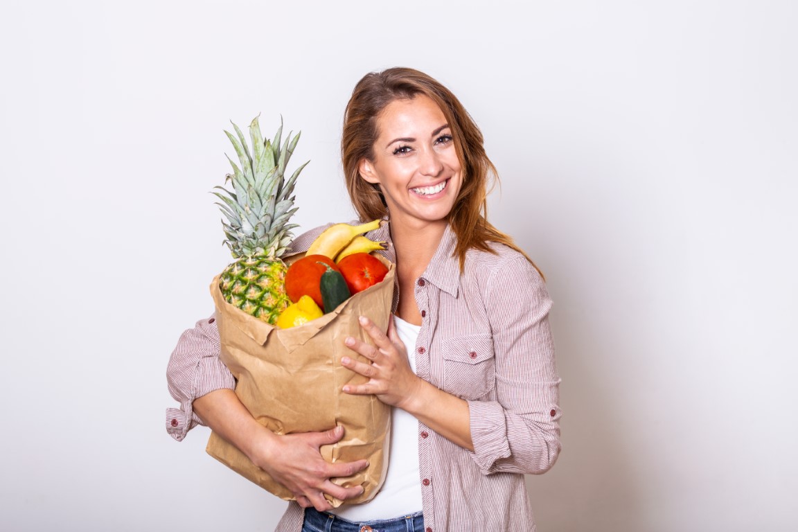 femme avec un sac de fruits et légumes